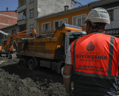 Fotoğraf galerisi öğesi 1/8, İstanbul Büyükşehir Belediyesi yol bakım çalışmasında kamyon ve ekskavatörü izleyen baretli mühendis.